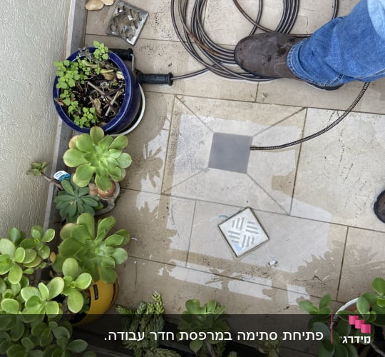 כבל אינסטלציה על רצפה ליד רגליים וניקוז